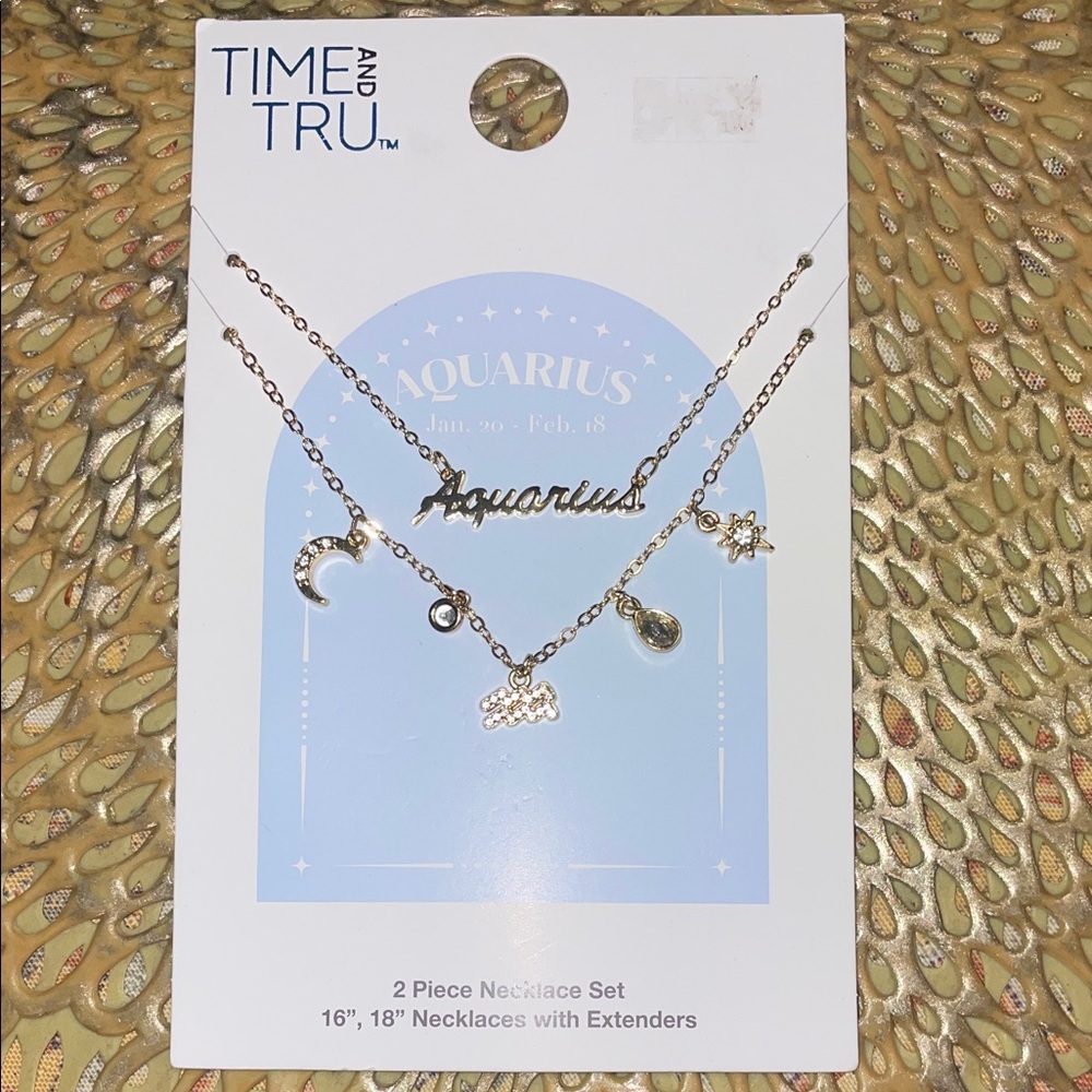 Set of 2 Adjustable Aquarius yellow gold tone necklaces with extenders & charms.